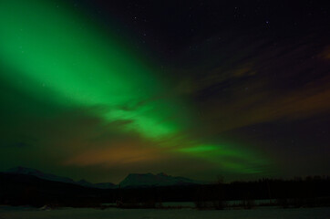 beautiful aurora borealis over arctic circle landscape in winter