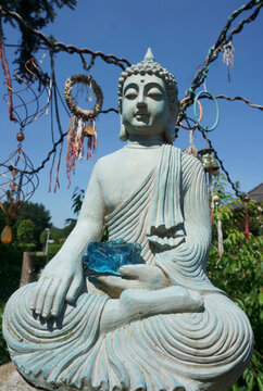 Sitzender meditierender Buddha mit einem blauen Glasstein in der Hand. Die Handbewegung bedeutet, die Erde zu rufen, um die Wahrheit zu bezeugen.