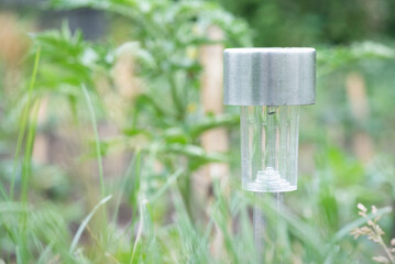 Solar garden lamp close up on a green grass background.