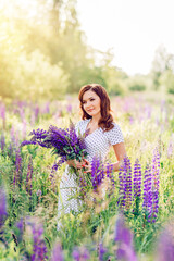 woman in a field with a bouquet of wild flowers