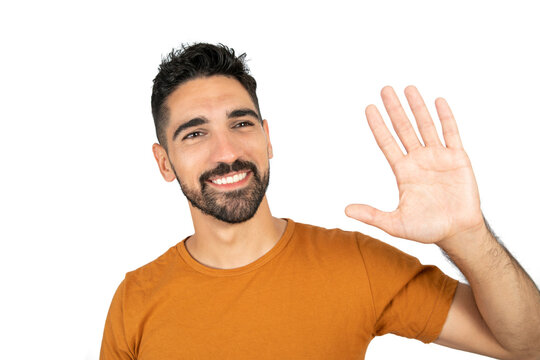 Young man waives hand in hello gesture.