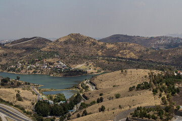 Aerial view of the last green hills left, surrounding Madin dam in Naucalpan, Mexico a fast-growing new urban living zone