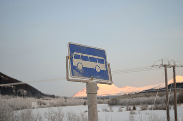 frost covered blue bus stop sign