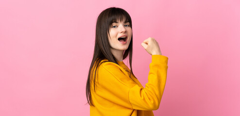 Young Ukrainian woman isolated on pink background doing strong gesture