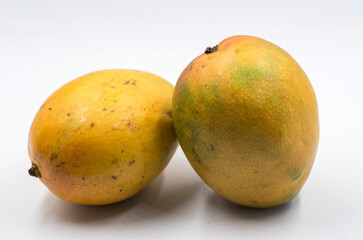 Two yellow and ripe mangoes isolated on white background