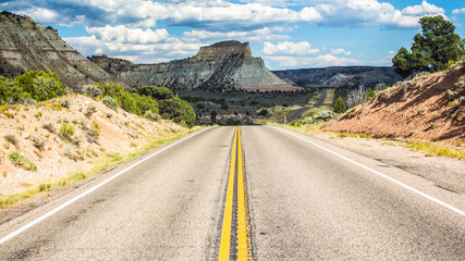 Endless empty road scenic Utah landscape with a sandstone mountain in the background