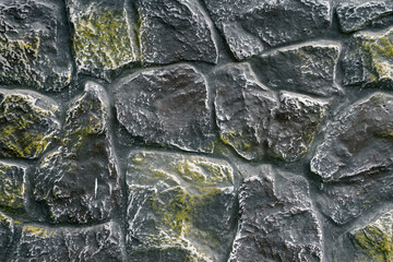 Fence or wall made of decorated gray green natural stone. Free space for text, logo or advertising