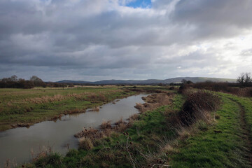 Fototapeta na wymiar Countryside landscape of River Ader and meadow near Shoreham-by-Sea, England