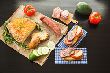 Cheesy Corn Bread with Sausage, Sandwiches and Vegetables on kitchen table.