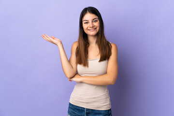 Young caucasian woman isolated on purple background extending hands to the side for inviting to come