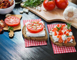 Healthy food. Vegetarian food. Italian bruschetta with White Goat Cheese with Tomatoes, Garlic and Rosemary. Cheese Vegetable Sandwich