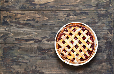 Cherry pie on a wooden background with place for text. View from above.