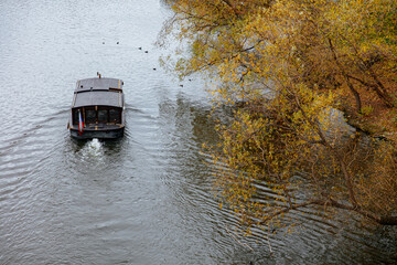 Dark wooden boat going with the stream of river