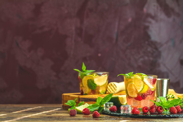 Refreshing mint cocktail mojito with rum, lime, mint, thyme, ice and raspberry. Alcohol or non alcohol summer fresh drink.