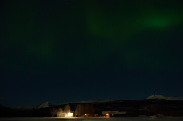 Aurora borealis over homestead in the arctic circle winter night