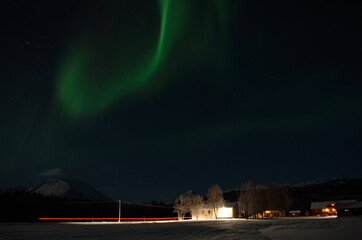 Aurora borealis over homestead in the arctic circle winter night