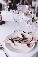 Wedding table setting. Tableware and decorations for serving a festive table. Plates, wine glasses and cutlery with decorative textile on white background. Table setting in restaurant. Wedding party. 