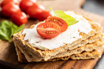 Dieting knackebrot. Crispbread with creamy cheese., cherry tomato and basil leaf.