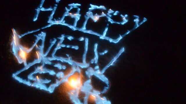 blue fire flames in snow spelling out happy new year
