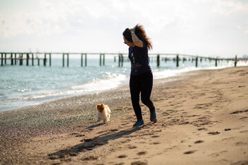 Young woman sunbathing on beach with her dog in Antalya / Turkey