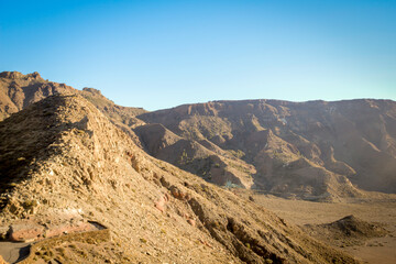 A dry mountain range in Tenerife, spain against a clear blue sky