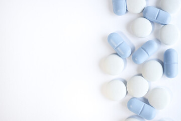 white and blue pills. Healthcare View from above. WITH PLACE for text from the left.WHITE BACKGROUND