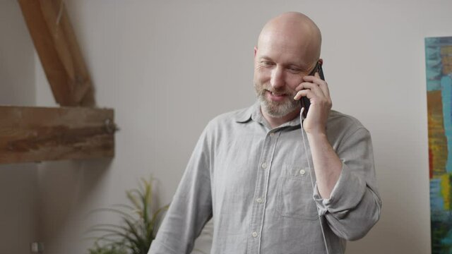 Man talks on his smartphone at his home office in slow motion