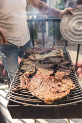 setting charcoal to make a family barbecue of meat on a grill