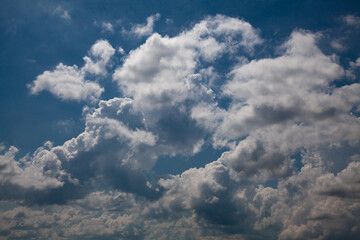 White cumulus clouds against a deep blue sky