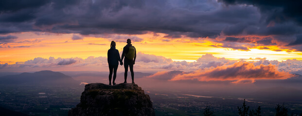 Fantasy Adventure Composite of a Man and Woman Couple on a Rocky Mountain Peak during a colorful...