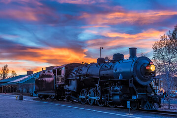 The train to the Grand Canyon waiting at Williams Station, Arizona illuminated by a fiery sunset sky