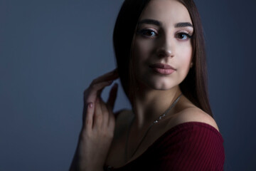 Art studio of a dramatic portrait of a young beautiful girl, with artistic retouching. Close-up, girl's face, with an expressive look. On a dark background. Beauty portrait