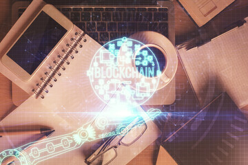 Double exposure of blockchain theme hologram over table with phone. Top view. Crypto technology...