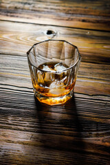 single malt whiskey with ice on the rock on wooden table top view