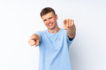 Young handsome man over isolated white background points finger at you while smiling