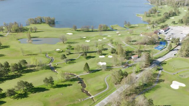 Aerial view of golf course, clubhouse, trees and water