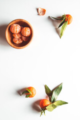 beautiful ripe tangerines with green leaves on wooden plate