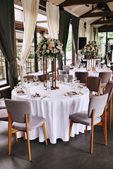 Restaurant interior. Wedding decoration. Flowers on the table. Wedding party.  Elegant tableware.  Table setting