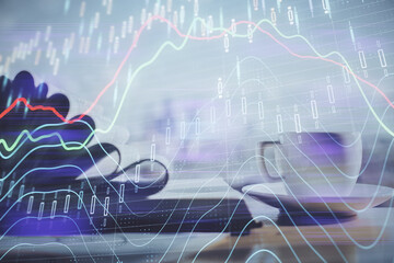 Double exposure of financial chart drawing and desktop with coffee and items on table background....