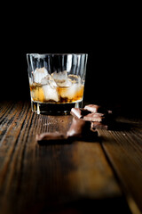 malt scotch whiskey with ice and chocolate on wooden table