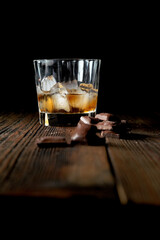 malt scotch whiskey with ice and chocolate on wooden table
