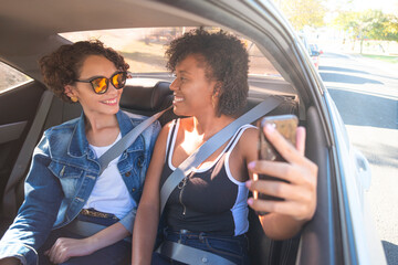 Friends taking pictures inside the car. Concept of transport by application.