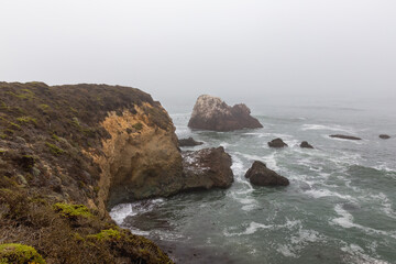 rocks and sea in fog on coast of Big Sur, California