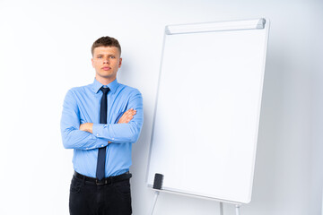 Young businessman giving a presentation on white board with arms crossed while giving a presentation on white board