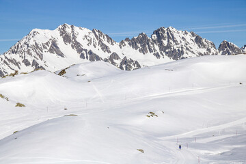 Fototapeta na wymiar personne marchant seule dans la neige en haute altitude à l'alpes d'Huez, france