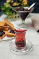Toast slices with red jam and a glass of tea 