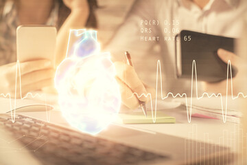 Double exposure of man and woman working together and human heart hologram drawing. Medical education concept. Computer background.
