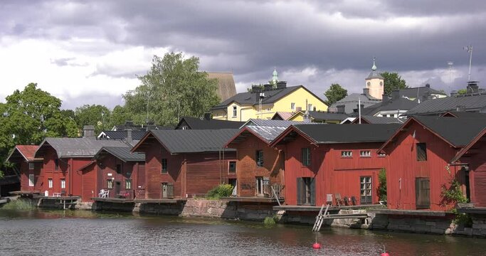 4K video of Porvoo vintage red wooden buildings, Porvoo Cathedral, yachts and boats in Porvoonjoki River near town center on sunny summer day in Finland, northern Europe