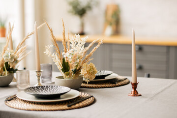 there is a plate on the table, there is a bouquet of flowers and a candle