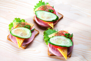 Sandwich with sausage and cheese, herbs, tomato and cucumber . Snack in the afternoon. A sandwich with you. Toasts for breakfast or lunch
